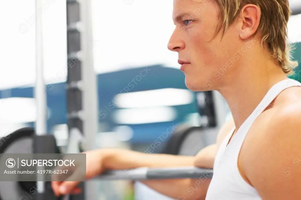 Profile of a focused-looking young man in the gym