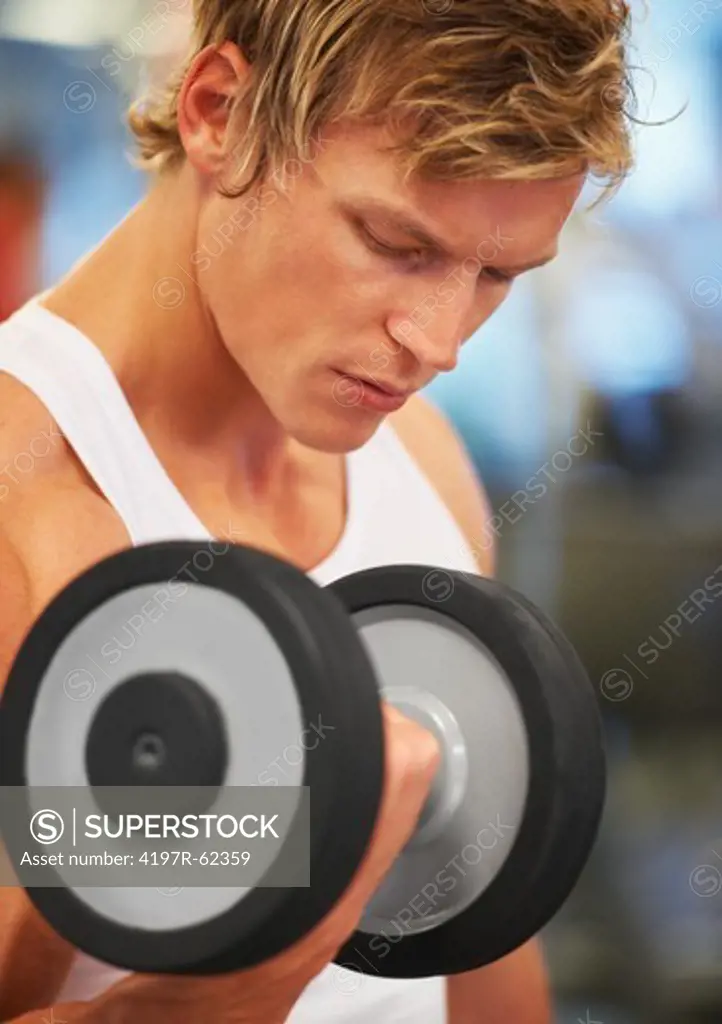 A young man pumping iron in the gym