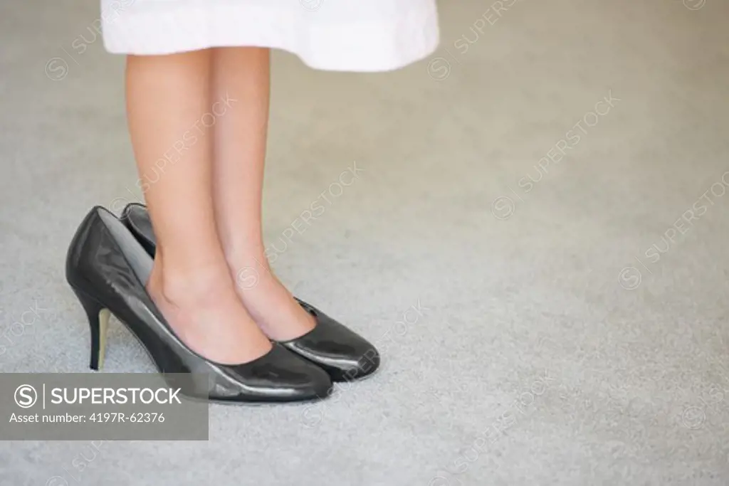 Cropped image of a young girl wearing her mother's high heels