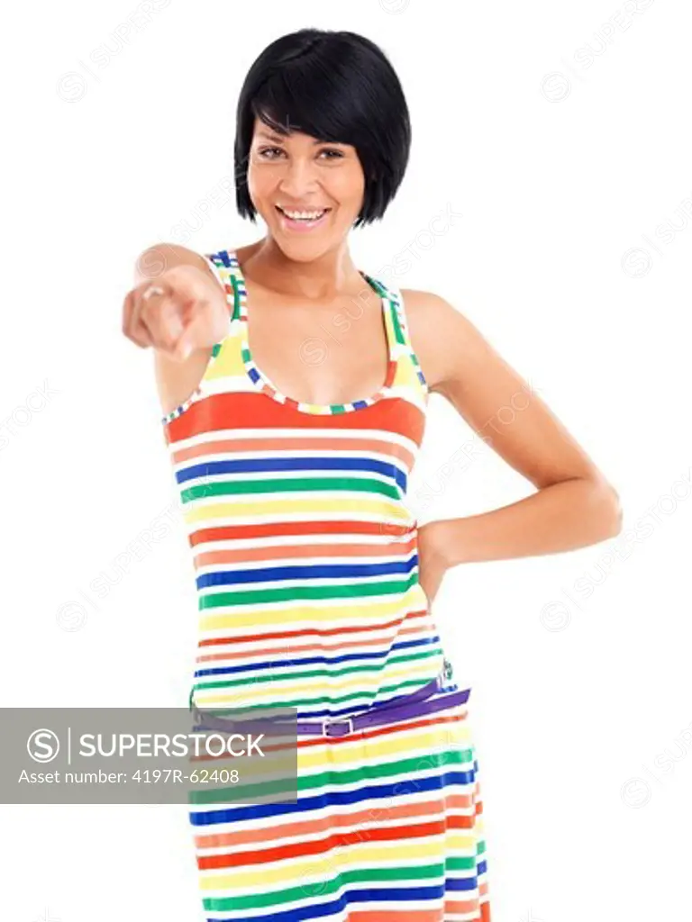 Casual young woman smiling while pointing and standing against a white background