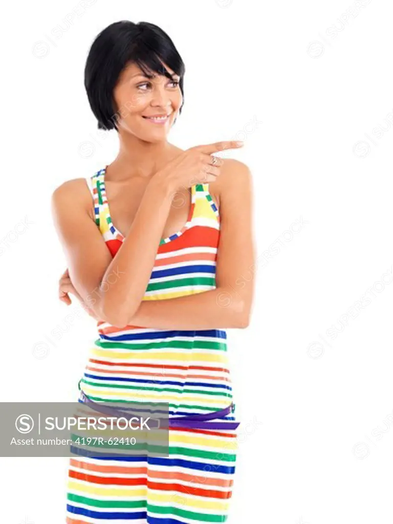 Casual young woman smiling while pointing away against a white background
