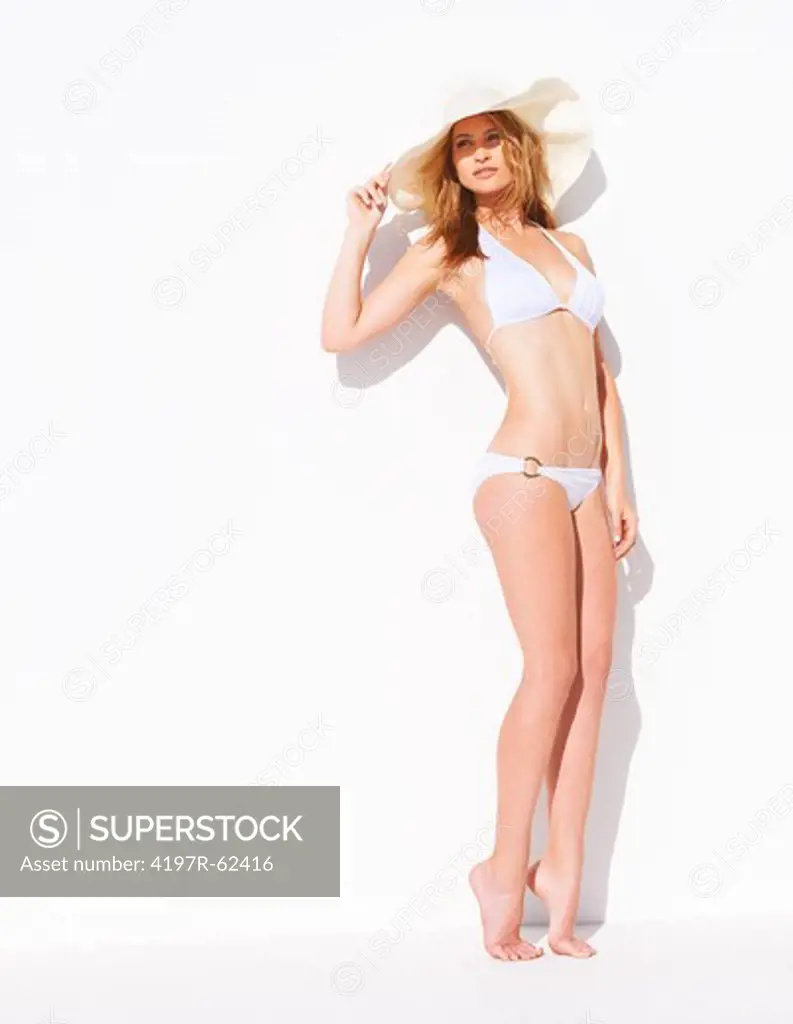 Stylish young woman wearing a white bikini and a sunhat