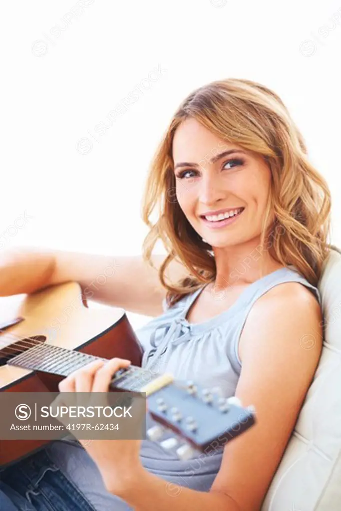 Smiling young woman holding her guitar and playing some music