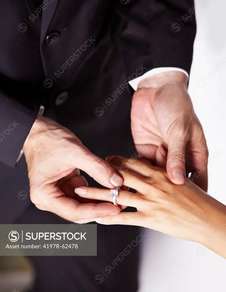 Cropped image of a husband putting the ring on his wife's finger