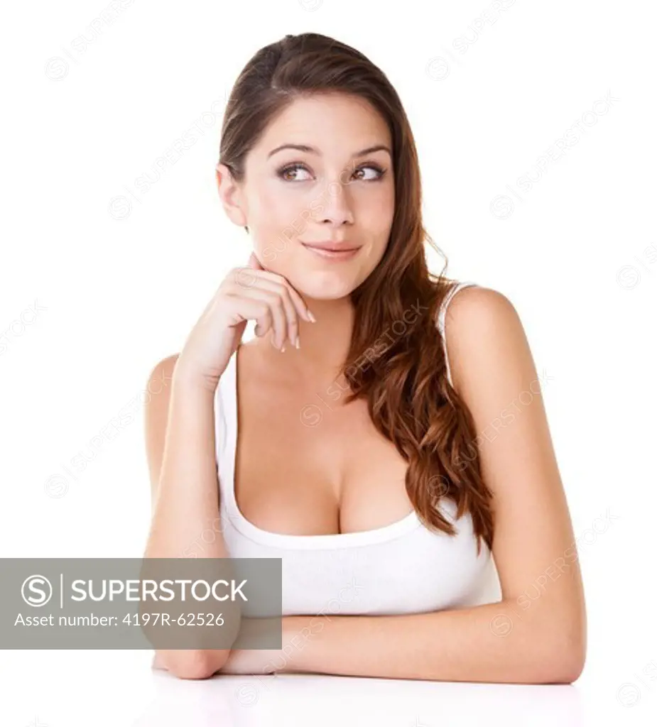 Studio shot of an attractive young brunette looking upwards with her hands on her chin isolated on white