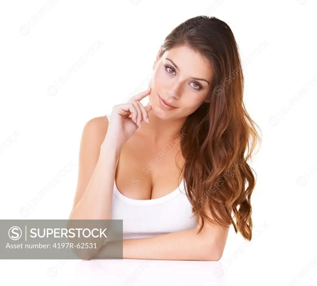 Studio portrait of an attractive young brunette with her hand on her chin looking alluringly at the camera isolated on white