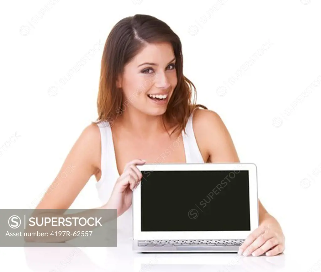Studio portrait of an happy-looking young woman displaying a blank laptop screen at the camera