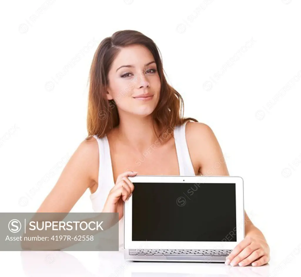 Studio portrait of an attractive young woman displaying a blank laptop screen at the camera isolated on white