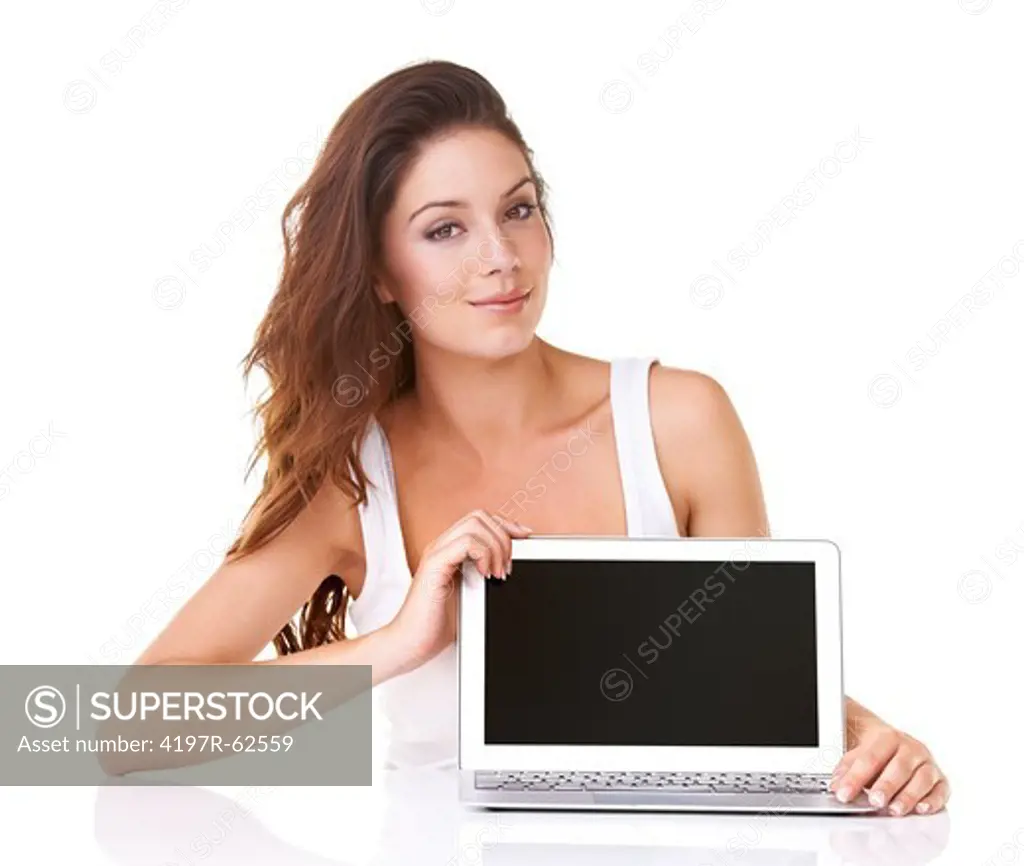 Studio portrait of an attractive young woman displaying a blank laptop screen at the camera
