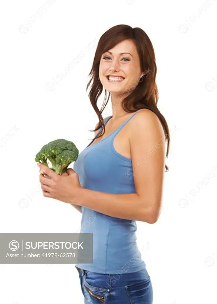 Studio shot of a young woman standing sideways and holding a head of broccoli isolated on white