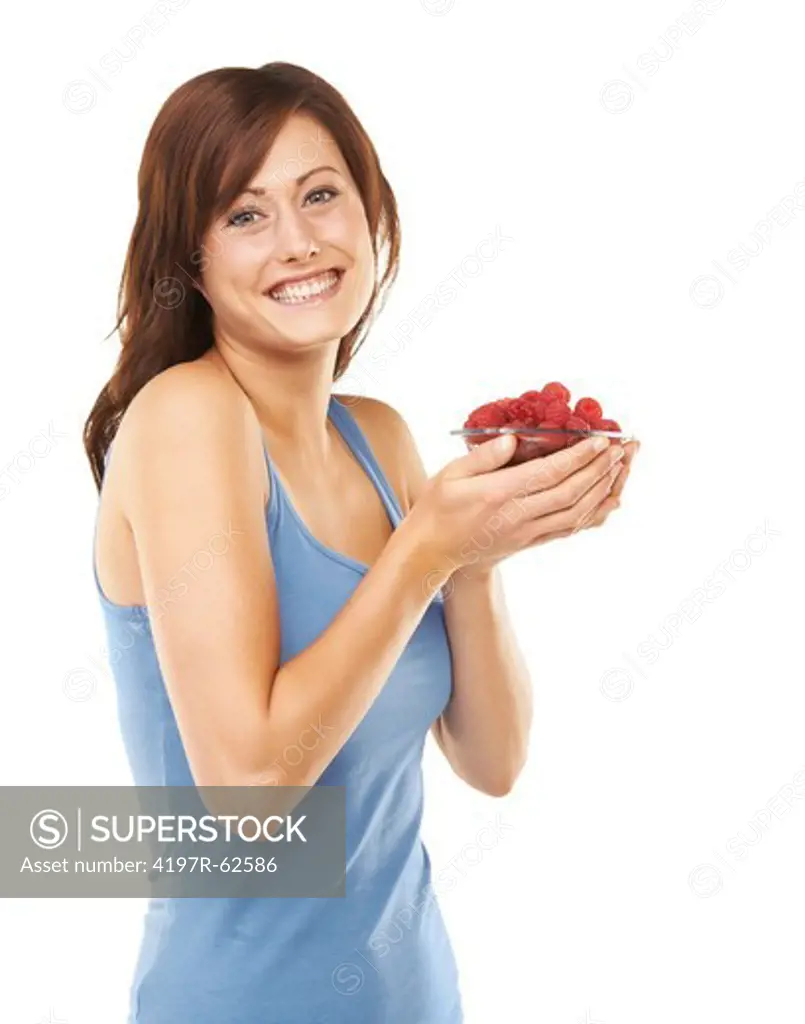 Studio portrait of an attractive young woman holding a bowl full of raspberries isolated on white