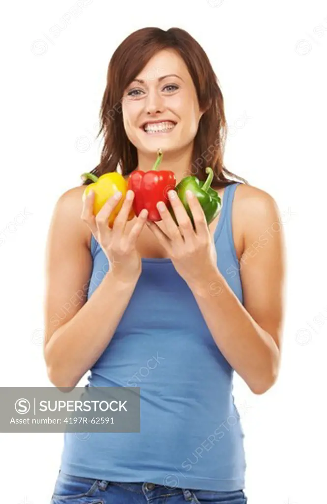 Studio portrait of an attractive young woman holding up a bunch of peppers with both hands isolated on white