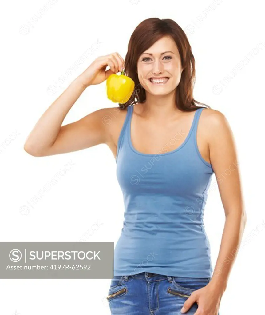 Studio portrait of an attractive young woman holding up a yellow capsicum in one hand isolated on white