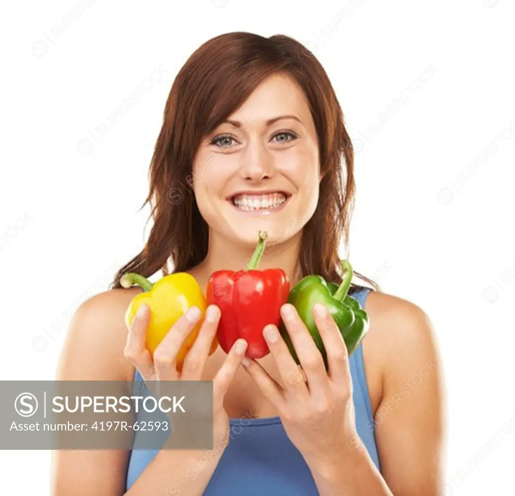 Studio portrait of an attractive young woman holding up a bunch of peppers with both hands isolated on white
