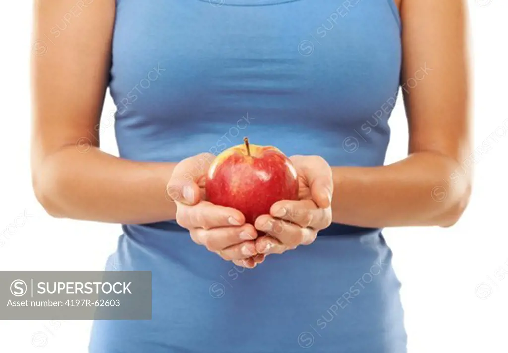 Closeup cropped studio shot of a woman holding an apple at waist level isolated on white
