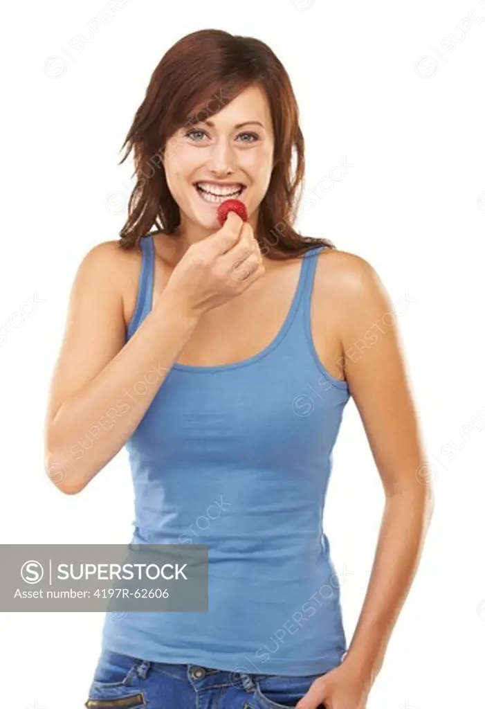 Studio portrait of an attractive young woman eating a strawberry isolated on white