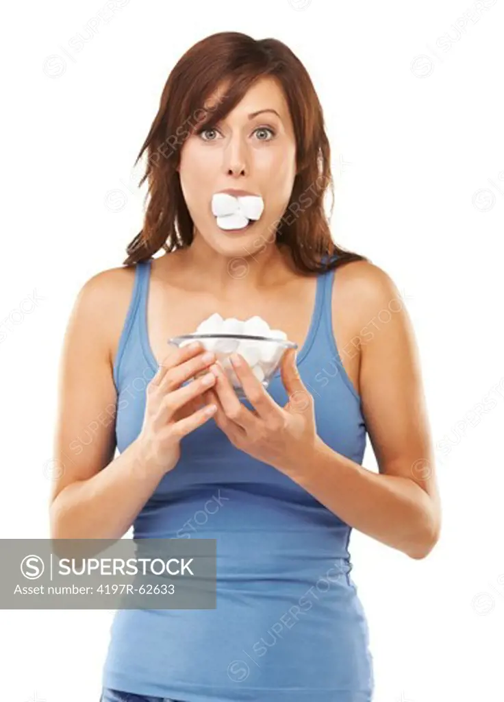 Studio portrait of a young woman with marshmellows stuffed in her mouth isolated on white