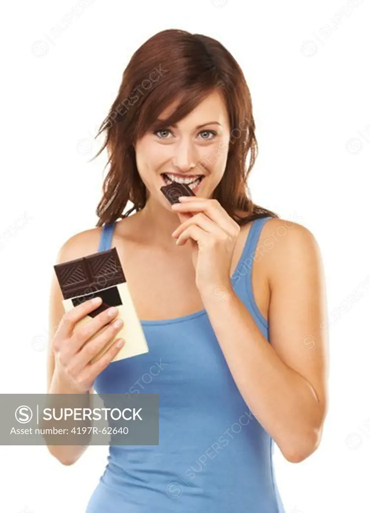 Studio portrait of a young woman taking a bite out of a huge chocolate bar isolated on white