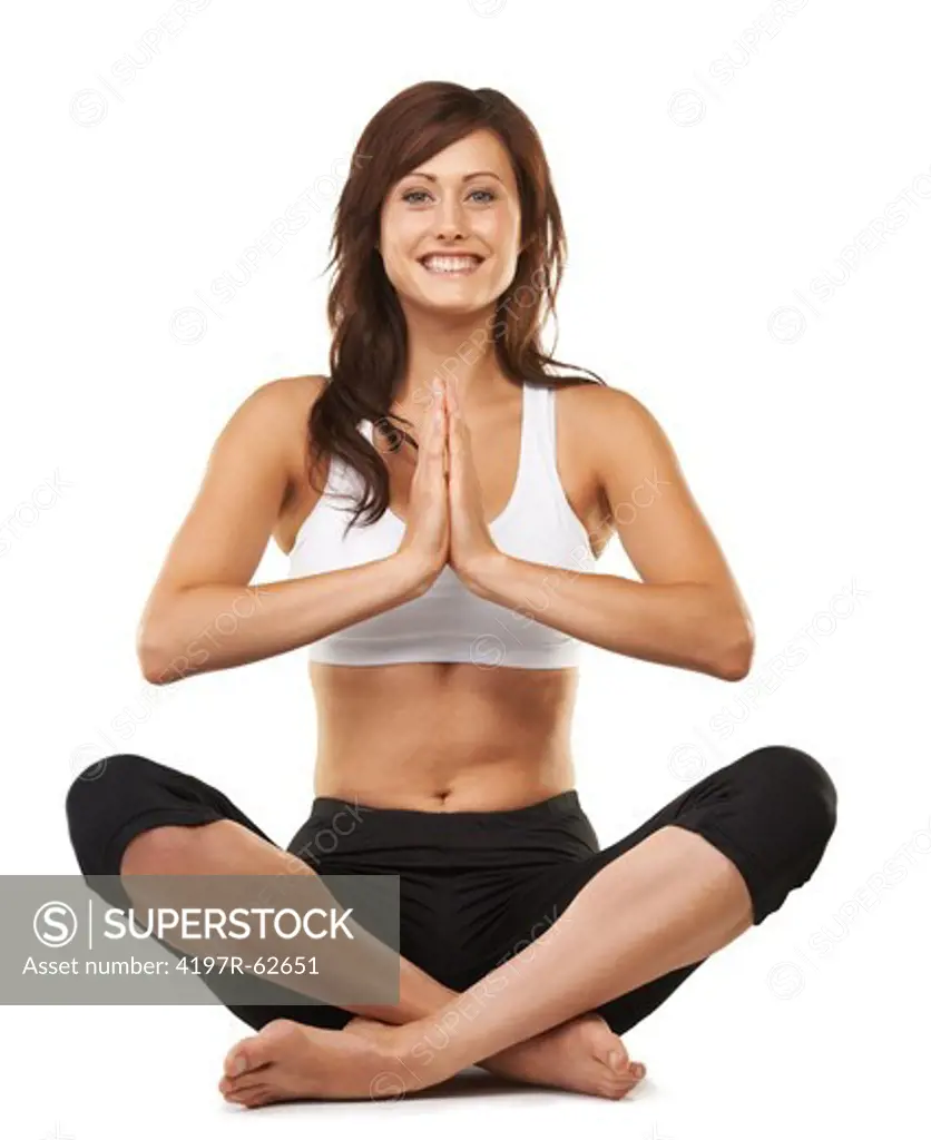 Studio shot of an attractive young woman sitting cross-legged in a meditative posture isolated on white