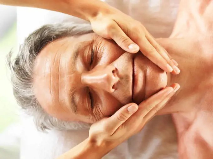 Closeup of mature man getting a face massage at the spa salon