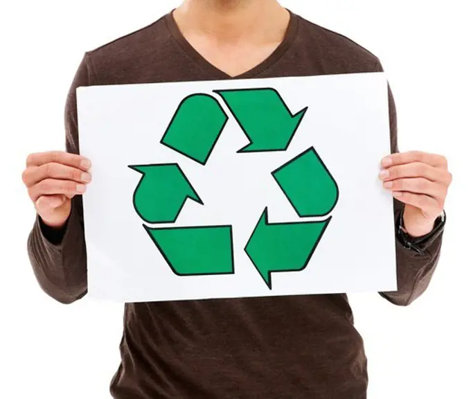 Cropped imageof a young man holding up a recycle sign