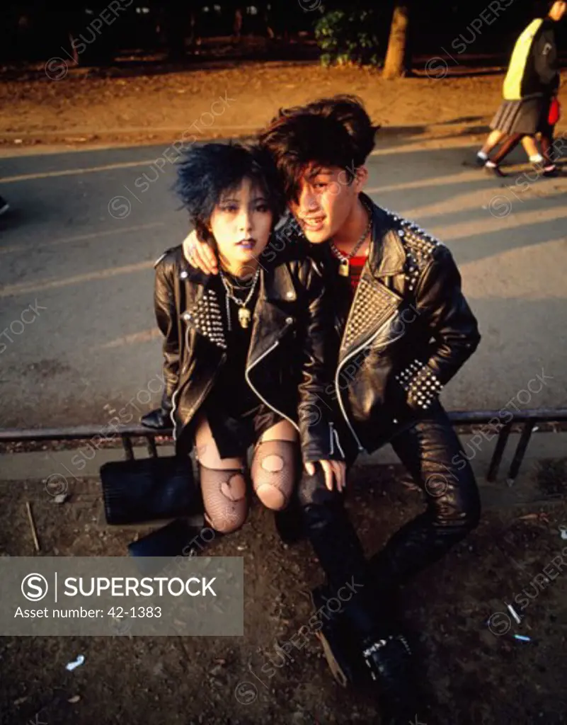 Portrait of a teenage couple sitting on a railing, Harajuku, Tokyo Prefecture, Japan