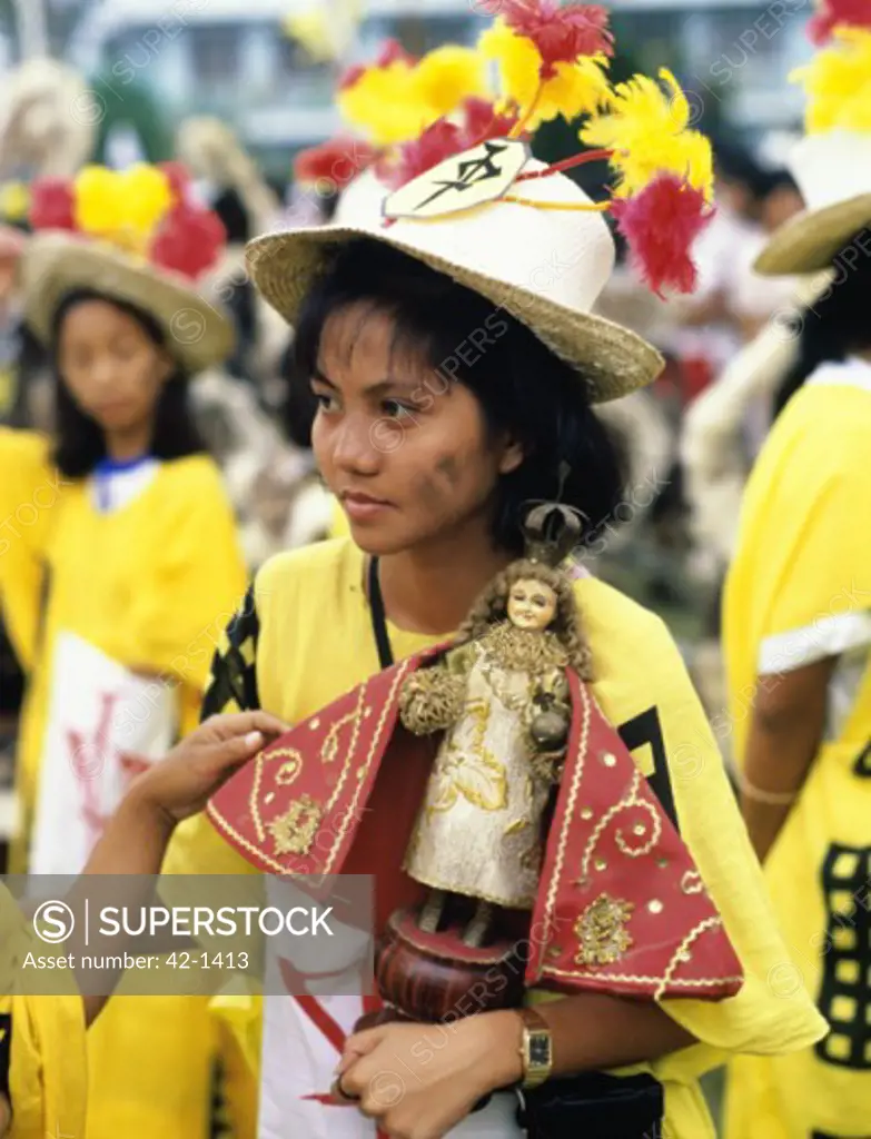 Girt dressed in traditional clothing holding a doll, Ati-Atihan Festival, Aklan Province, Philippines