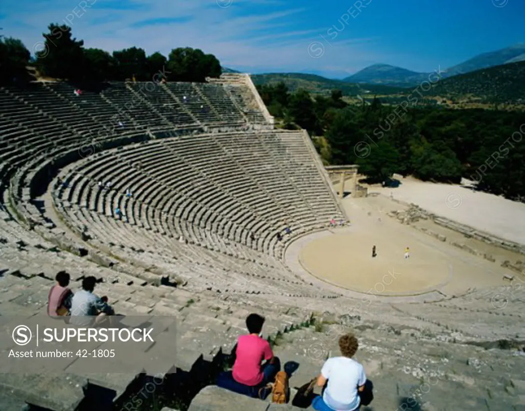 High angle view of tourists sitting on steps in an amphitheater, Epidaurus, Greece
