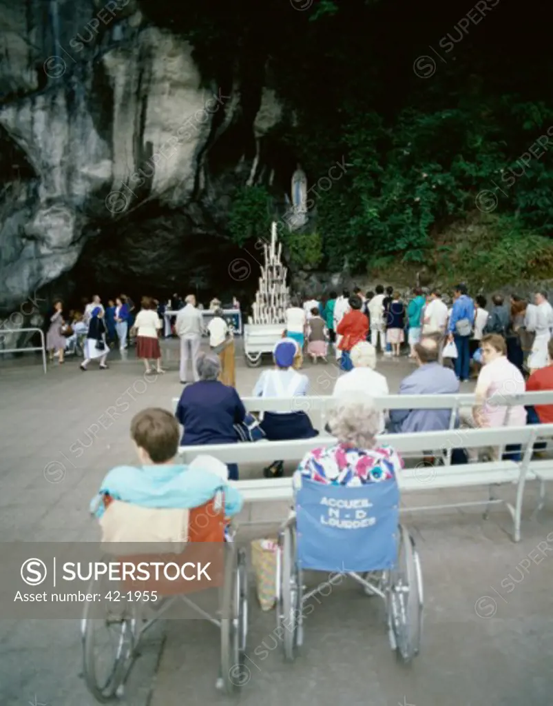 Group of people praying in front of a grotto, The Grotto of Massabielle, Lourdes, France