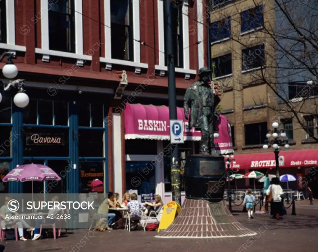 Tourists sitting at a sidewalk cafe, Gassy Jack Statue, Gastown, Vancouver, British Columbia, Canada