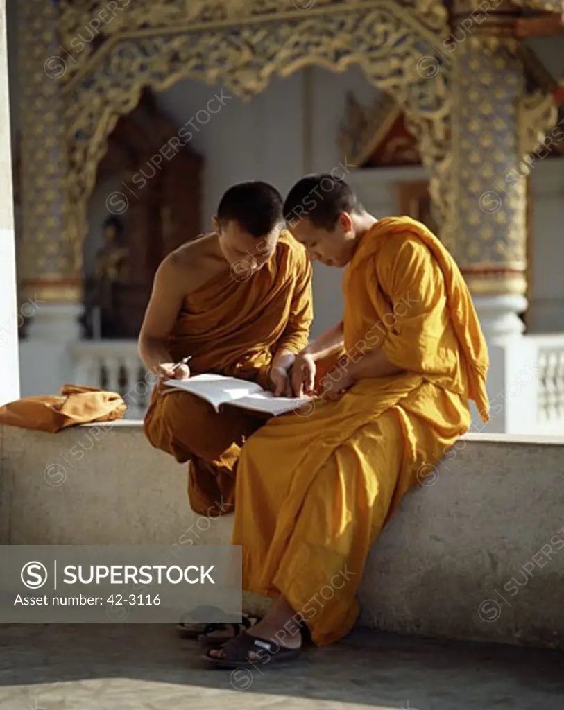 Two monks reading a book, Wat Phra Singh, Chiang Mai, Thailand