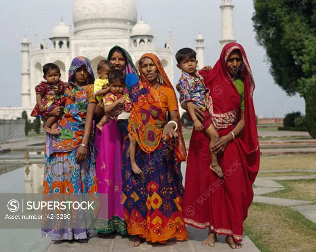 Group of women wearing traditional costumes standing in front of the Taj Mahal, Agra, Uttar Pradesh, India