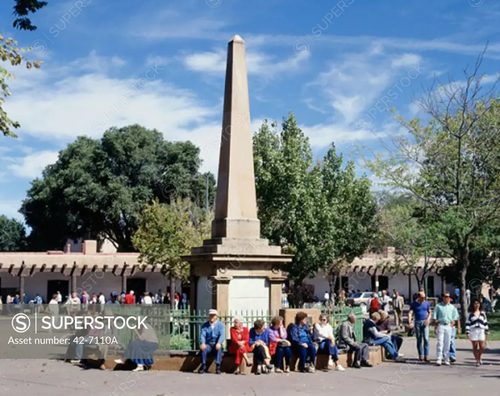 Group of people sitting in a town square, Old Santa Fe Plaza, Santa Fe, New Mexico, USA