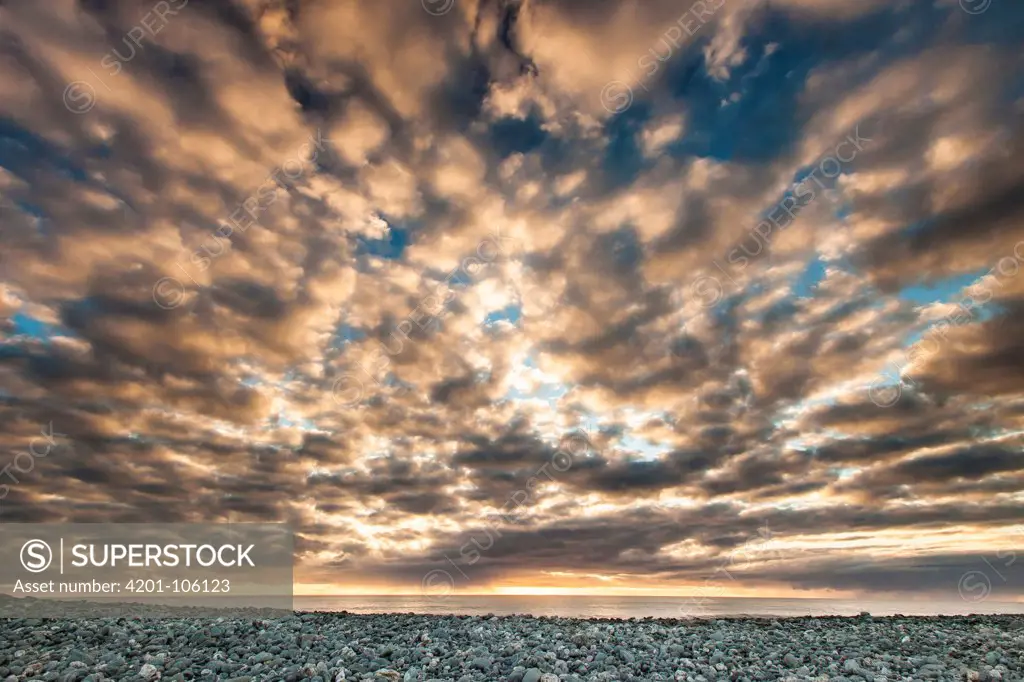 High clouds over ocean at sunset, Gillespies Beach, South Island, New Zealand