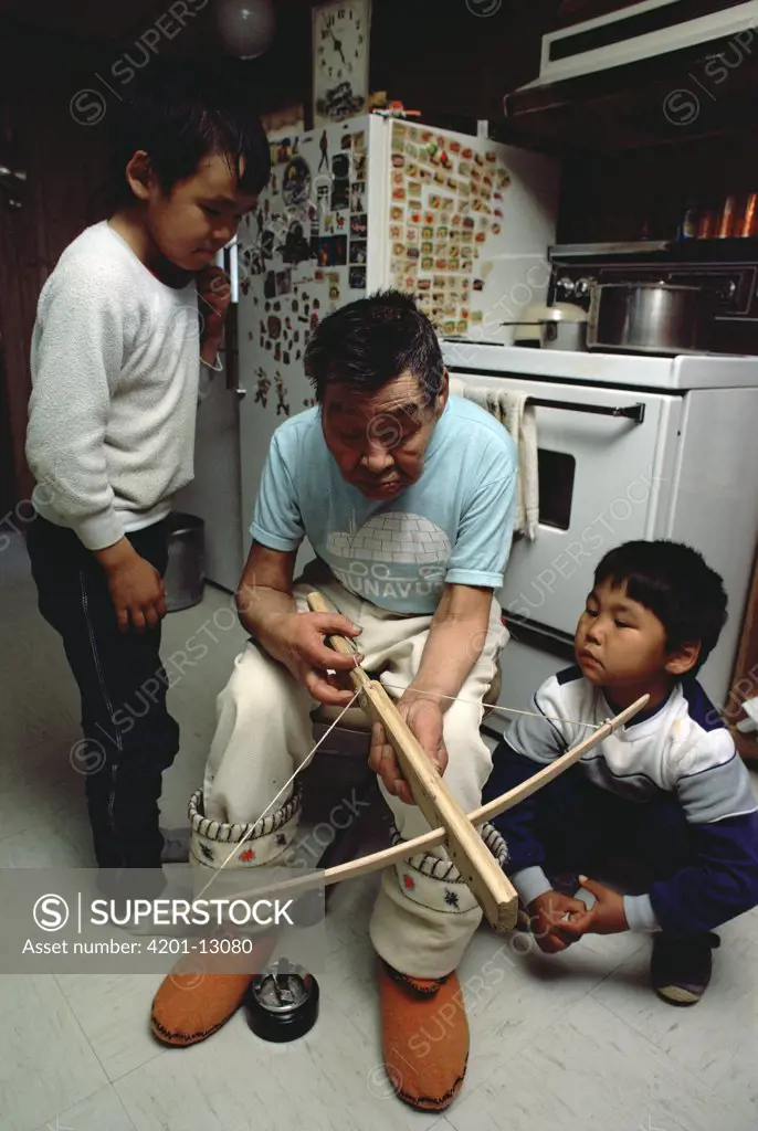 Philipoosie Novalinge shows kids how to use crossbow, he was a role model for the documentary Nanook of the North, Ellesmere Island, Nunavut, Canada