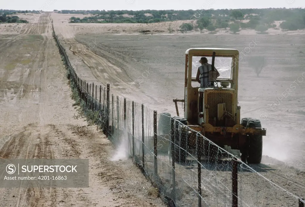 Tractor driving along dingo fence, Australia