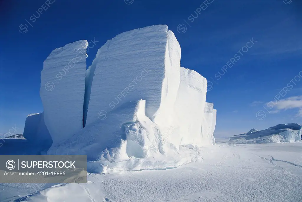 Grounded iceberg, calved from front of glacier, drifted into coast and locked in by sea ice, Antarctica