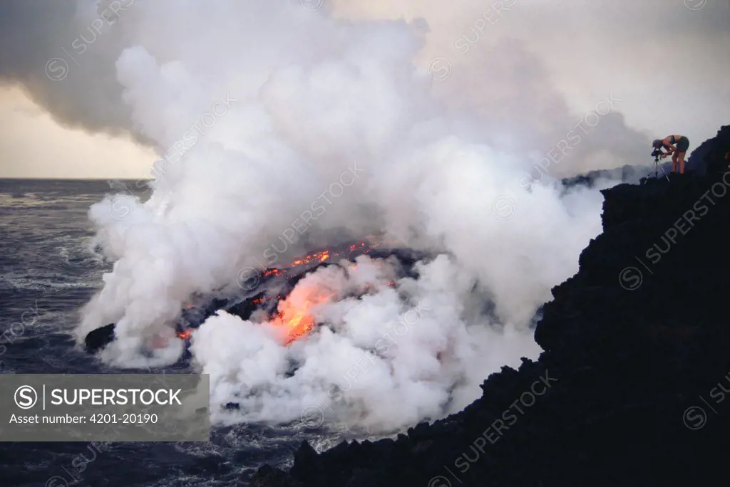 An Aa lava flow entering sea along steep shoreline with resulting steam plumes, Cape Hammond, Fernandina Island, Galapagos Islands, Ecuador