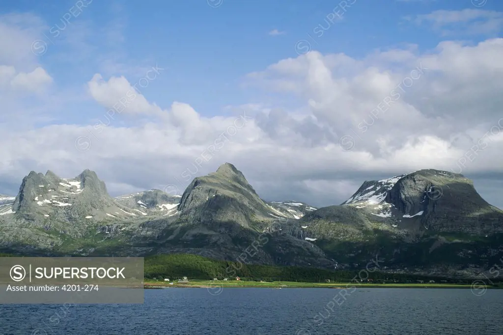 Norwegian fjord, small farming community along narrow coastal waterway, Seven Sisters mountain range of glacier sculpted granite, Norway