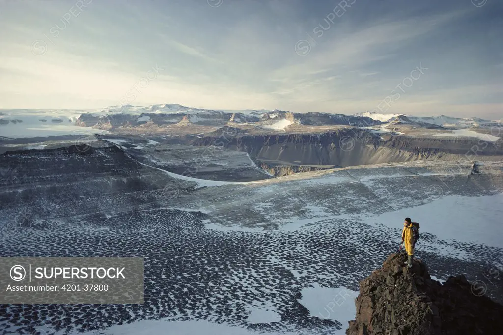 Man standing on a rock overlooking the Olympus Range, dry valleys, Antarctica