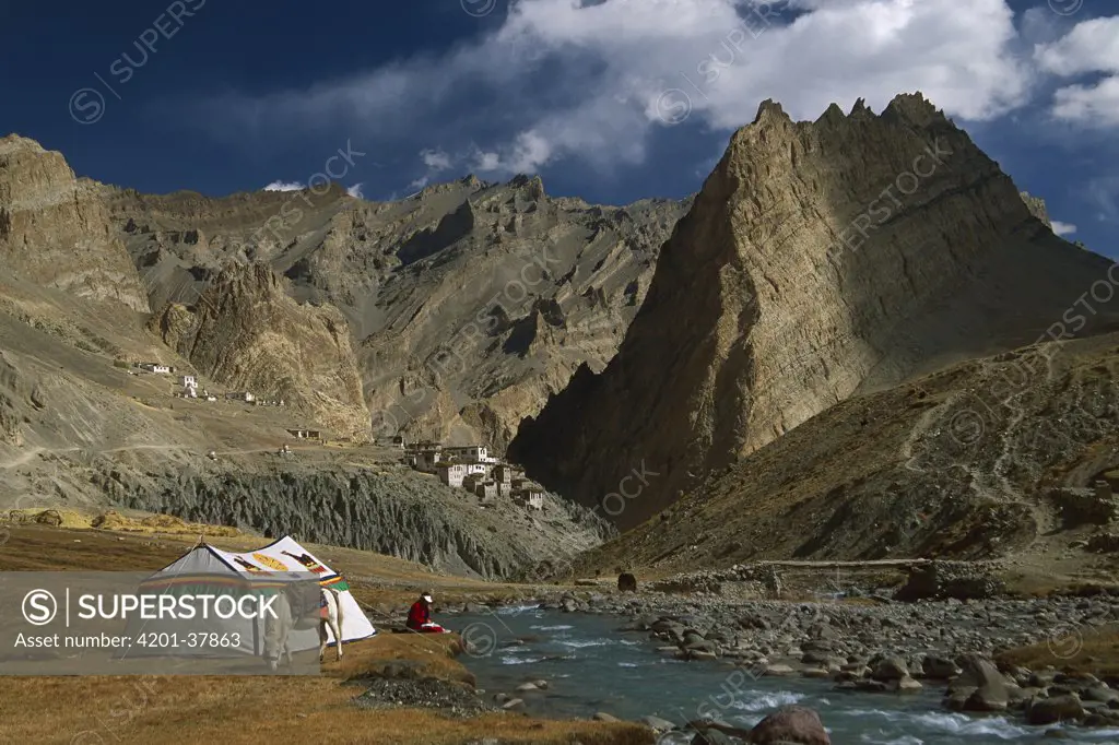 Trekker writes in diary beside Tibetan tent, Photoskar village, Ladakh, Himalayas, northwest India