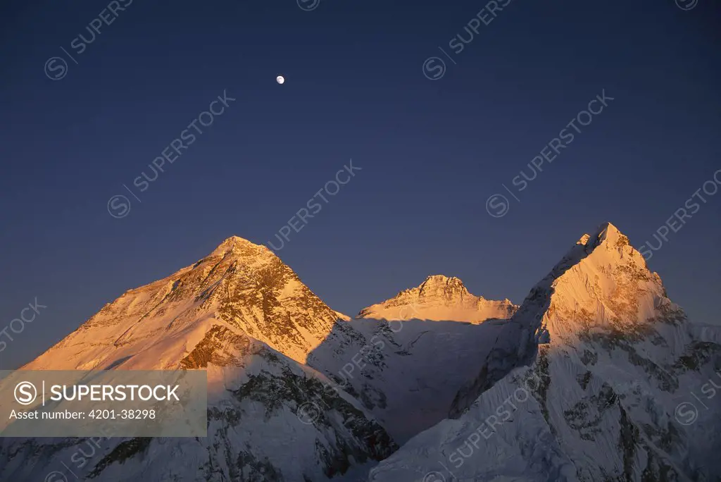 Moon over summit of Mount Everest, Lhotse, and Nuptse as seen from Mount Pumori at sunset, Sagarmatha National Park, Nepal
