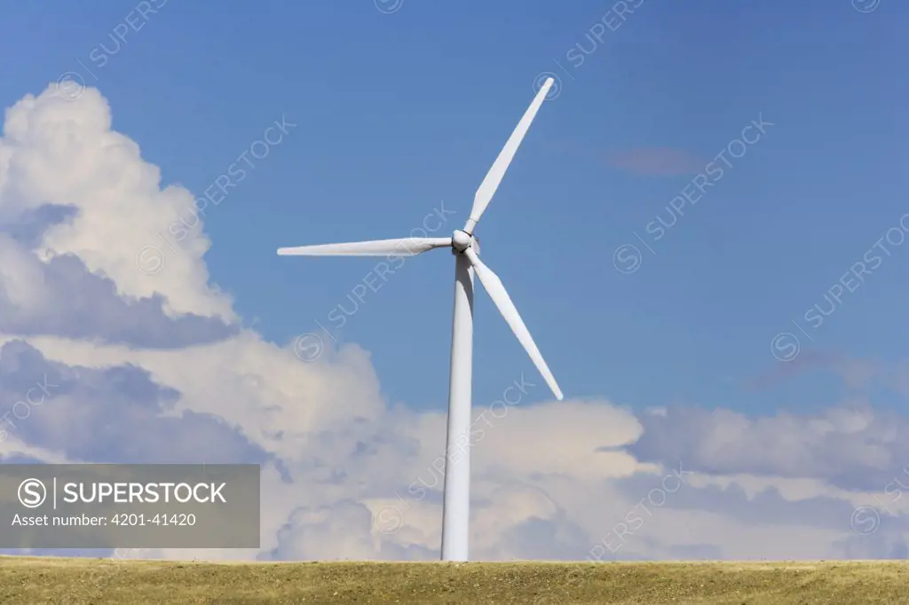 Windfarm turbine at work in high desert grasslands, summer, noon, Wyoming