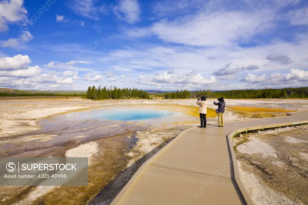 Tourists photgraphing Opal Pool, Midway Geyser Basin, Yellowstone National Park, Wyoming