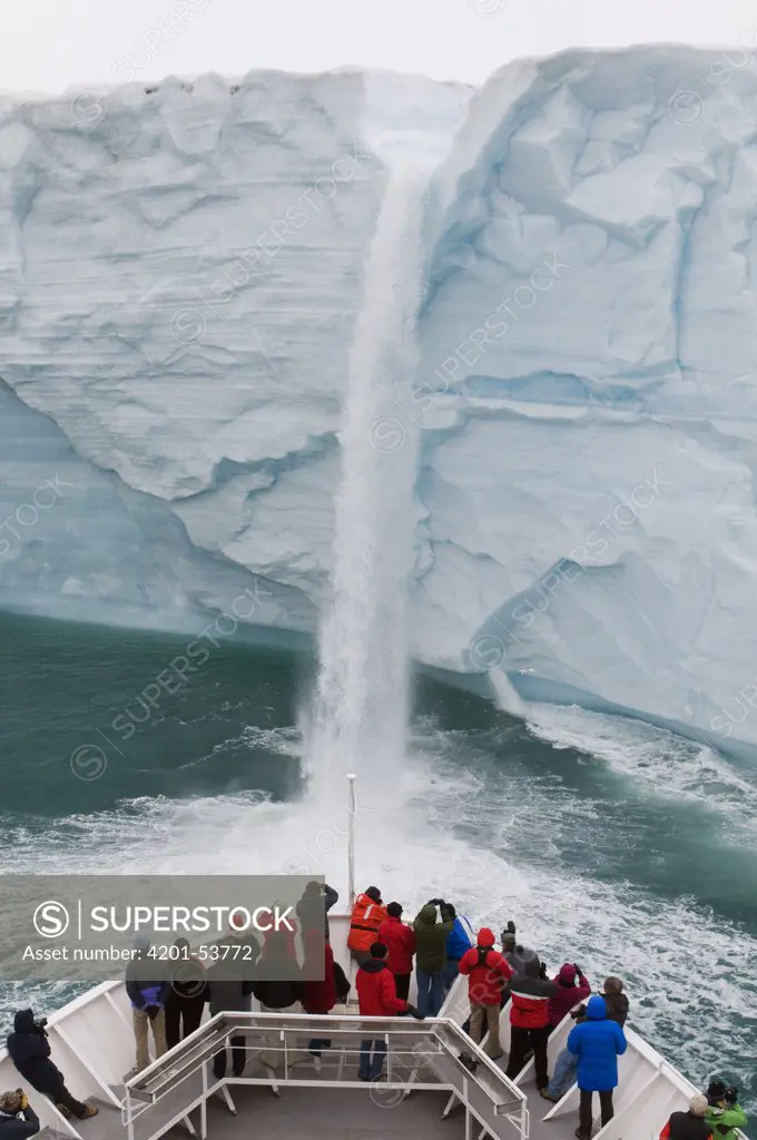 National Geographic Explorer ship approaches waterfall, Austfonna Glacier, Nordaustlandet, Svalbard, Norway