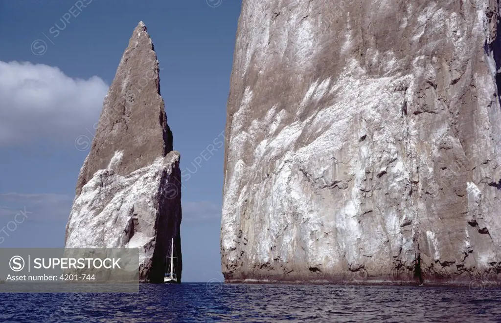 Sailboat dwarfed by Kicker Rock, an old eroded tuff cone, San Cristobal Island, Galapagos Islands, Ecuador