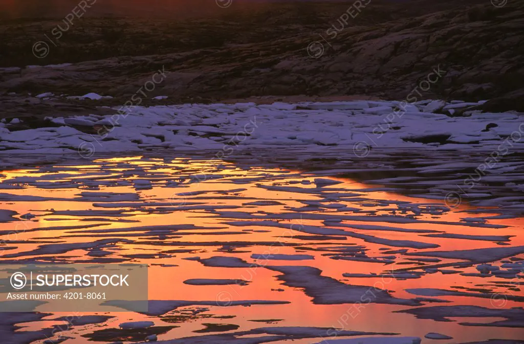 Melting ice reflecting midnight sunset, Wager Bay, Manitoba, Canada