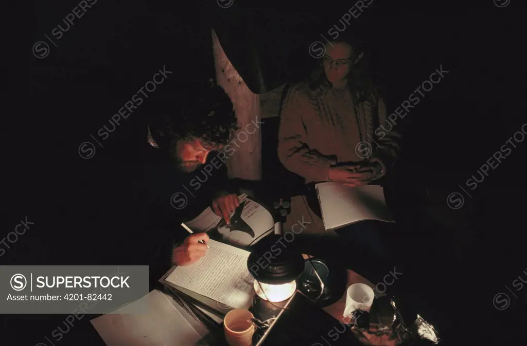 Orca researchers John Ford and Deborah Kavanagh reviewing data in tent, Vancouver Island, British Columbia, Canada