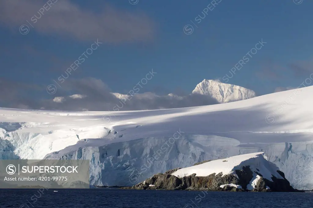 Glacier covered Melchior Islands with peaks of Brabant Island in background, Antarctica