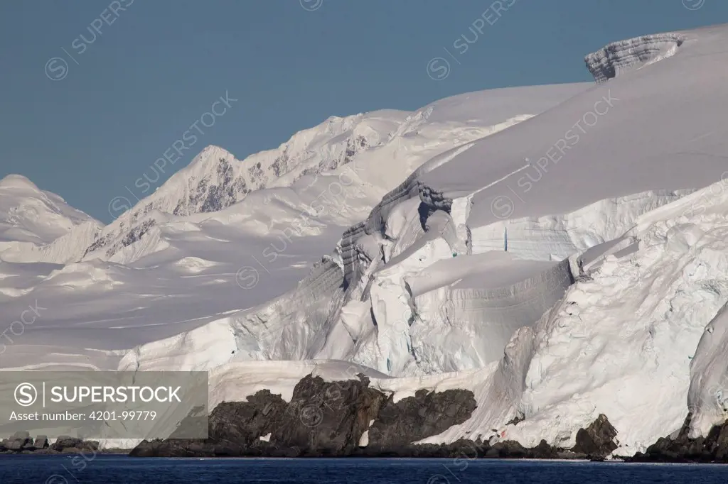 Glacier covered Melchior Islands with peaks of Brabant Island in background, Antarctica